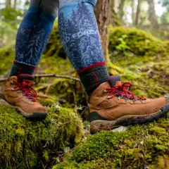 Hiking boots on mossy ground. Learn how to know if boots are too big by checking for heel slip and toe room.