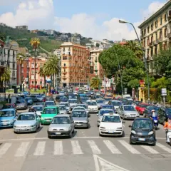 Busy street scene with cars and scooters, a typical day driving in Naples, Italy.