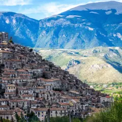 A picturesque village cascades down a mountainside, a perfect example of where to visit in Calabria for stunning views and historic charm.