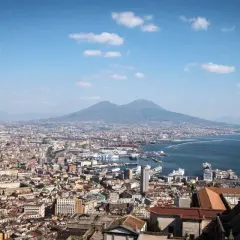 Panoramic view of Naples, Italy, with Mount Vesuvius in the background. Perfect for a Naples Italy itinerary, this vista captures the city's vibrant sprawl meeting the sea.