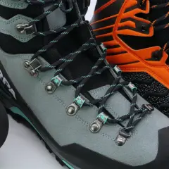 Close-up of three pairs of mountaineering boots, showing lacing details. Learn how to fit mountaineering boots for your next adventure.
