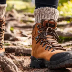 Brown leather hiking boots with thick socks, ready for the trail. Proper wanderschuhe pflegen ensures many adventures.