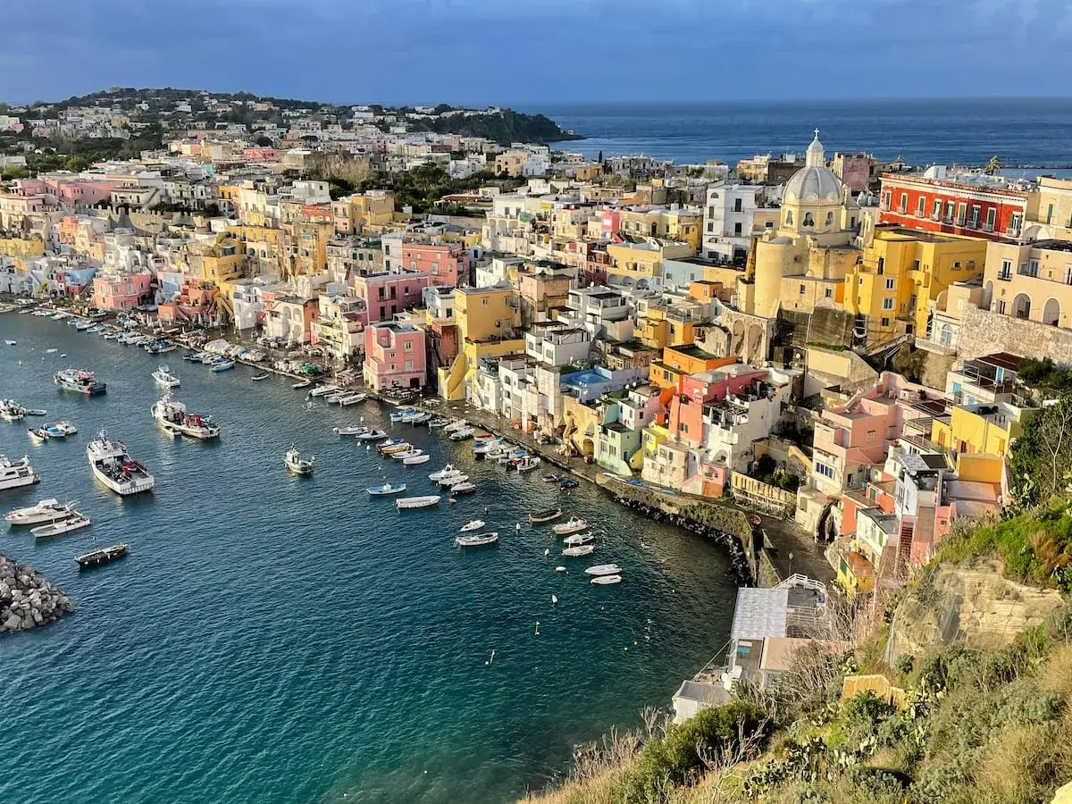 Colorful houses line a harbor filled with boats, a picturesque scene of things to do in Procida.
