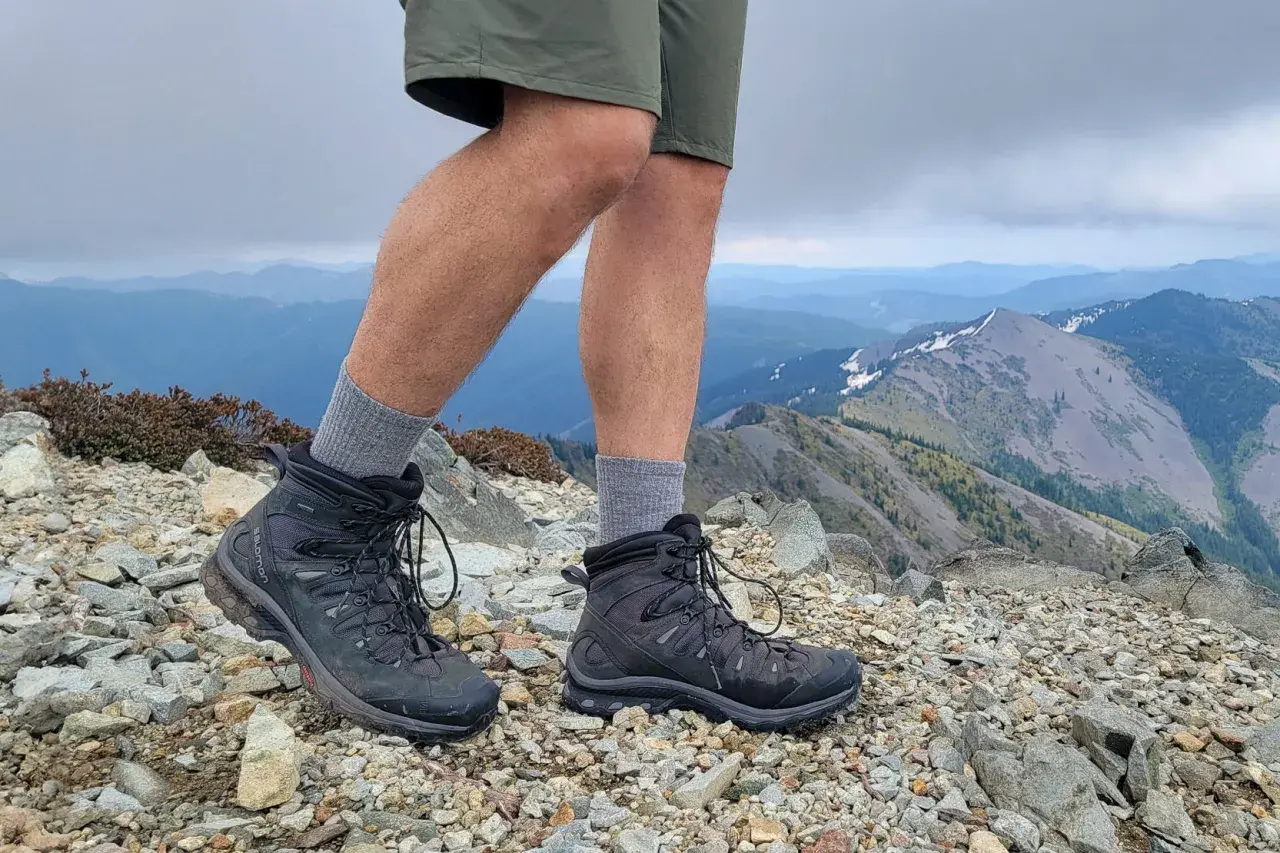 Hiking boots on a rocky summit. These boots look like they could last for years, answering the question: how long do leather boots last?