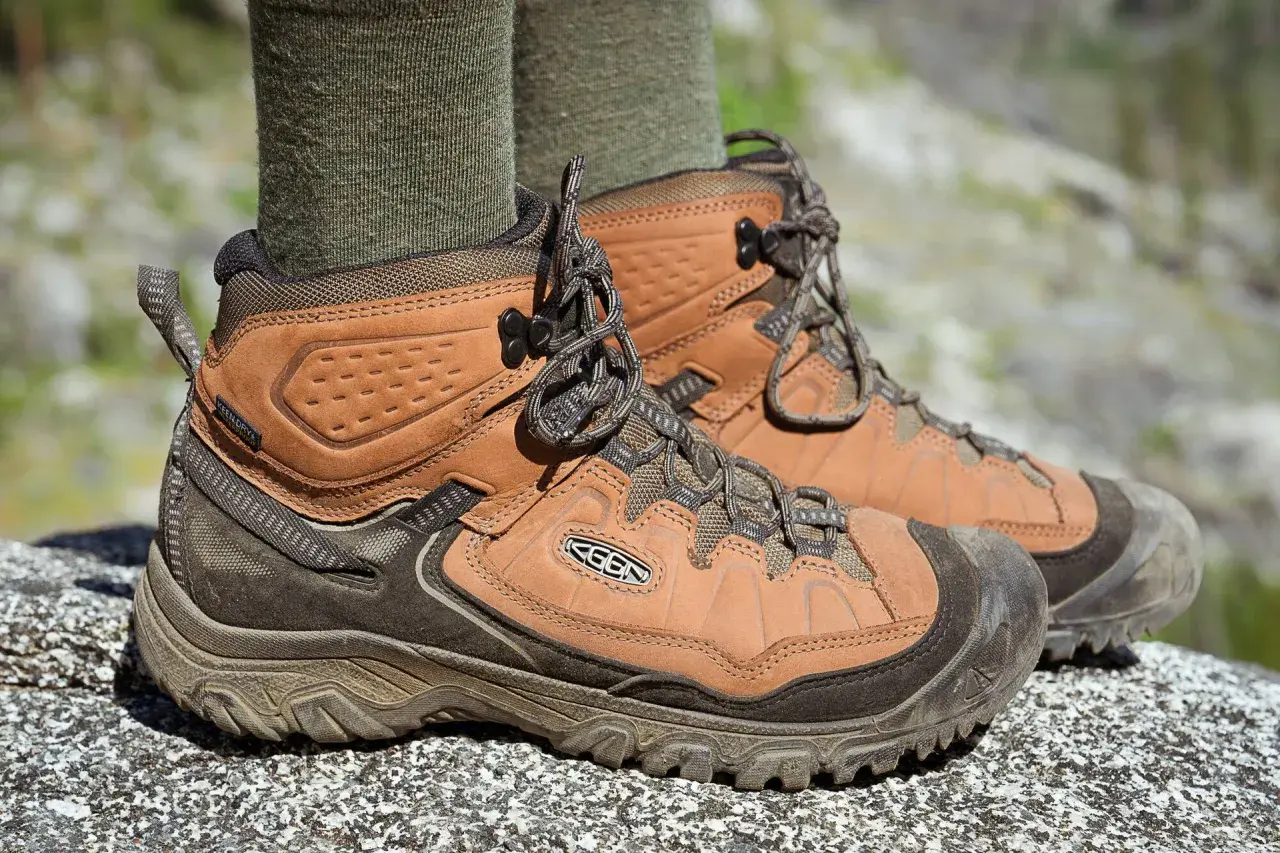 Brown leather hiking boots with green socks. They fit snugly, offering support for any trail.