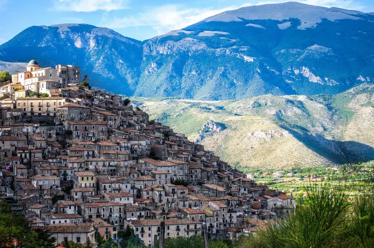 A picturesque village cascades down a mountainside, a perfect example of where to visit in Calabria for stunning views and historic charm.
