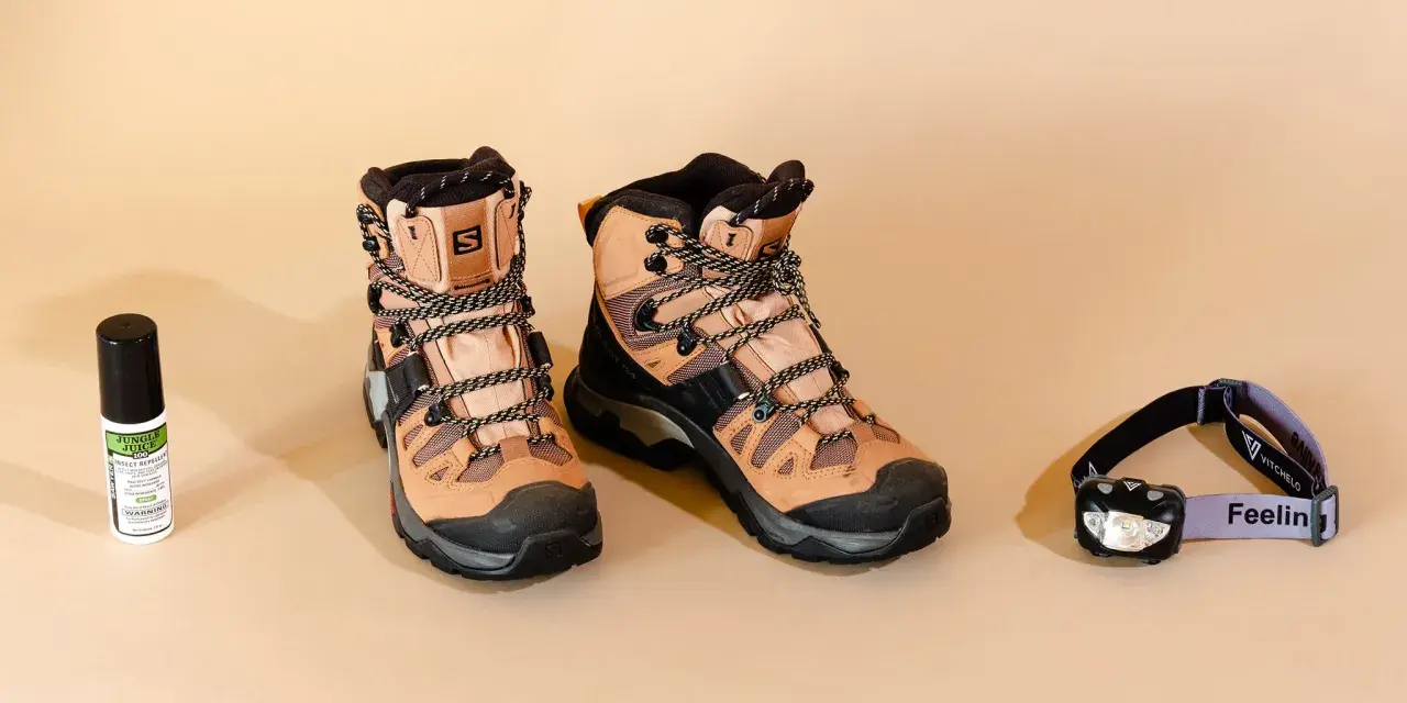 Hiking boots, insect repellent, and a headlamp are laid out. When choosing wanderschuhe worauf achten? Comfort and durability are key for any adventure.