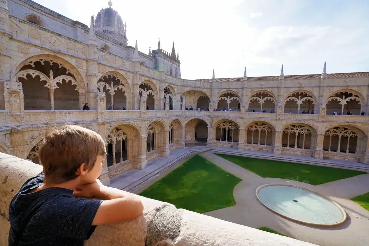 A boy gazes at the Jerónimos Monastery's cloister, a beautiful sight on one day in Lisbon.
