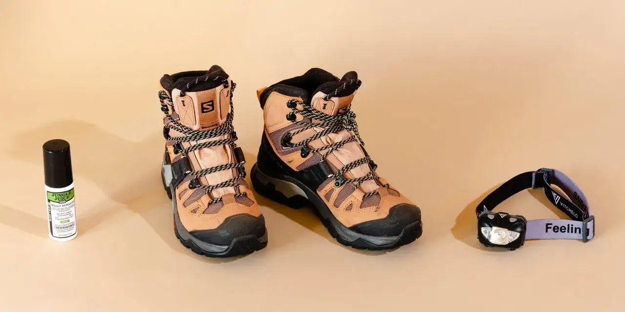 Hiking boots, insect repellent, and a headlamp are laid out. When choosing wanderschuhe worauf achten? Comfort and durability are key for any adventure.