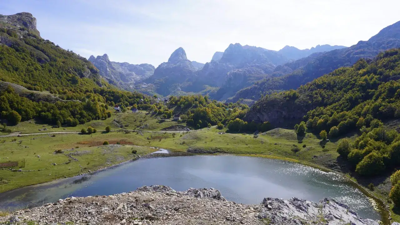 A serene lake reflects the majestic mountains of Montenegro. This view is perfect for any trip planner looking for breathtaking scenery.