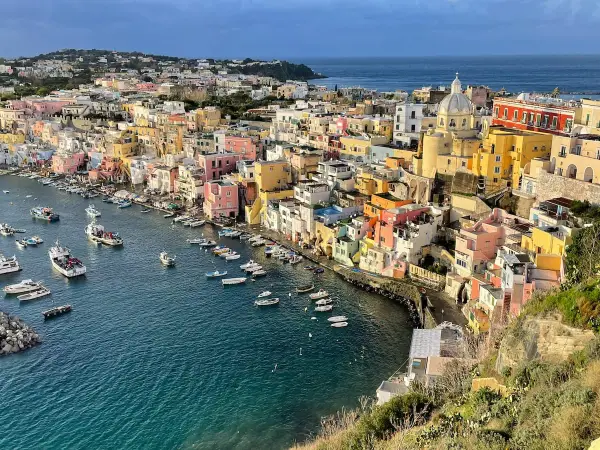 Colorful houses line a harbor filled with boats, a picturesque scene of things to do in Procida.